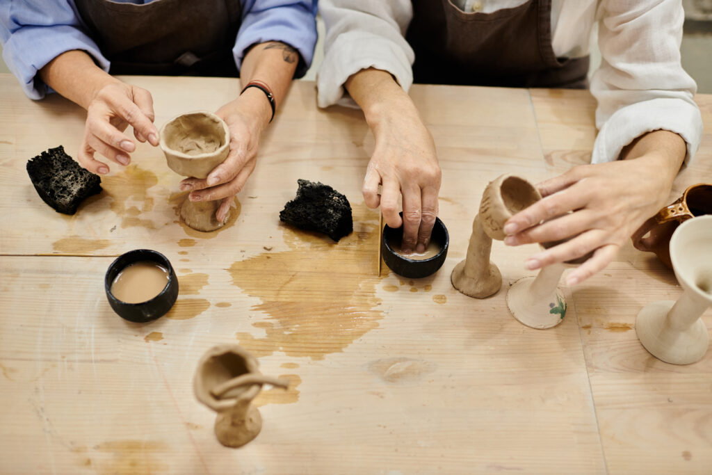 a mature lesbian couple crafts pottery together in a cozy studio setting.